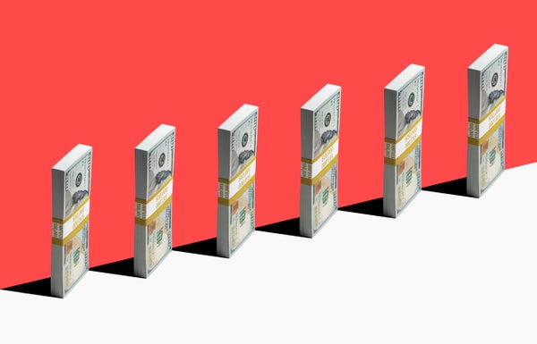 6 bundles of US $100 bills standing vertically on edge of white shelf.