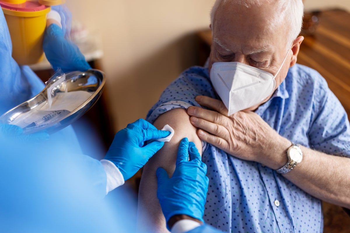 Older man receiving vaccination in shoulder