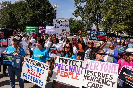 Crowd of women protesting with various signs.