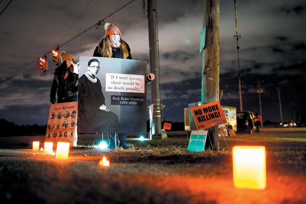 A woman protesting, holding a sign showing the Ruth Bader Ginsburg.