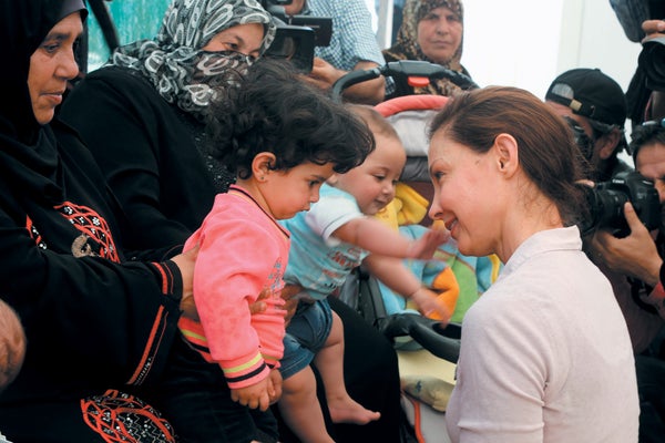 A woman looking at a baby, in a group setting.