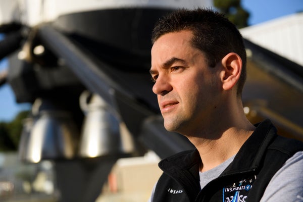 A photograph of billionaire astronaut Jared Isaacman standing in front of a rocket.