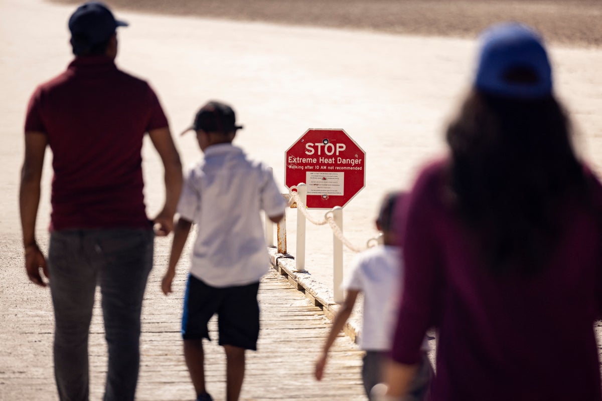 Visitors walk past a sign reading 