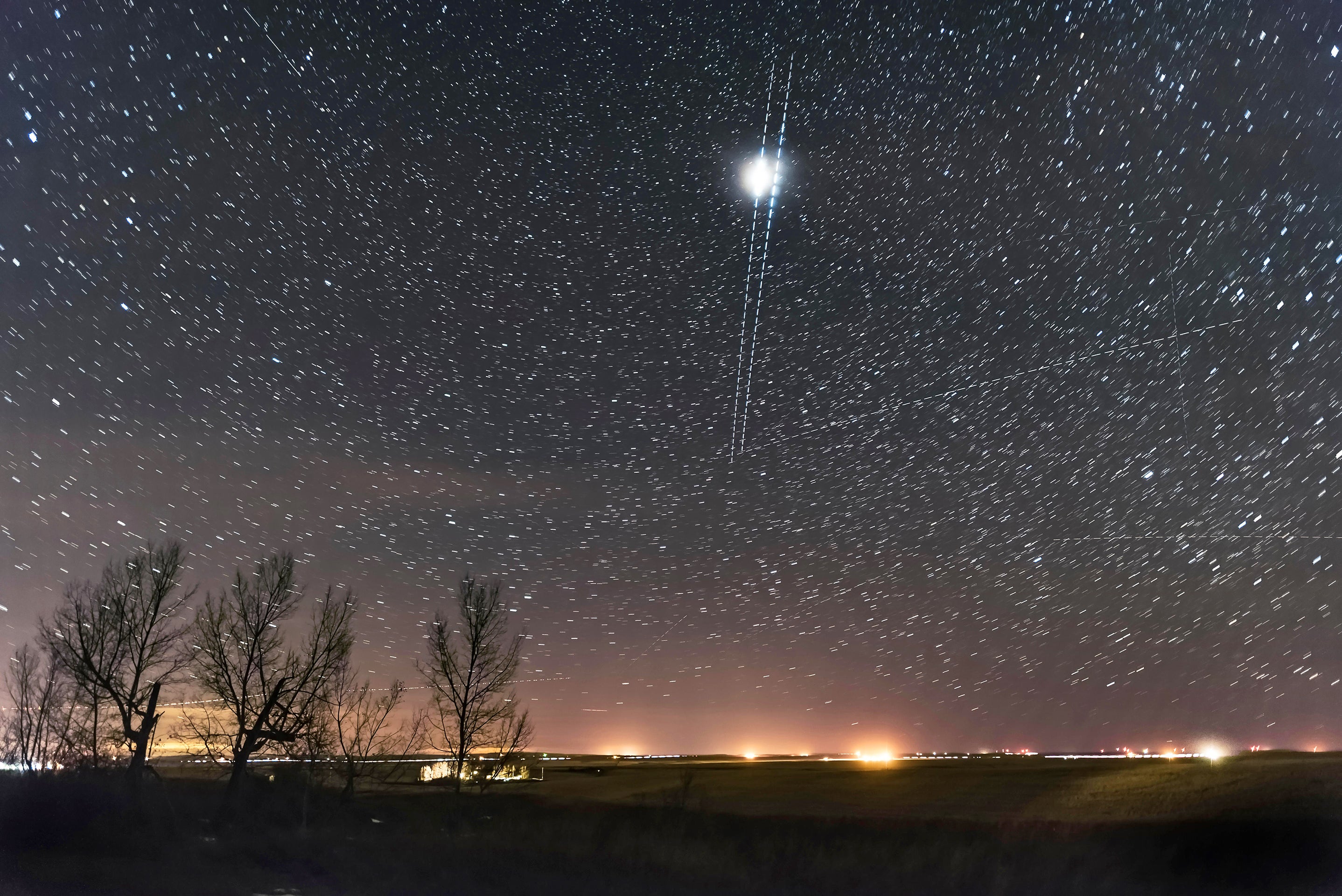 Photo of night sky. A pair of nearly simultaneous and parallel Iridium satellite flares as they descended into the north. The left or westerly flare was much brighter and with a sharp rise and fall in brightness. These are Iridium 90 (left) and Iridium 50 (right). Several other satellite trails are also in the picture.