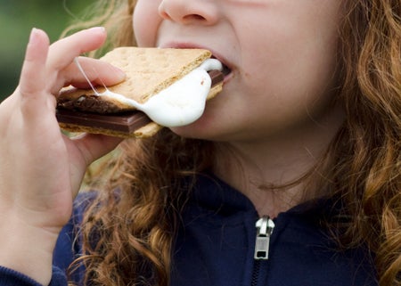 Young girl eating a s'more.