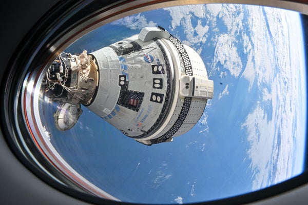 View from a window on the SpaceX Dragon Endeavour spacecraft of Boeing's Starliner. Both spacecrafts are docked to adjacent ports on the International Space Station. Earth can be seen in the background beyond the Starliner