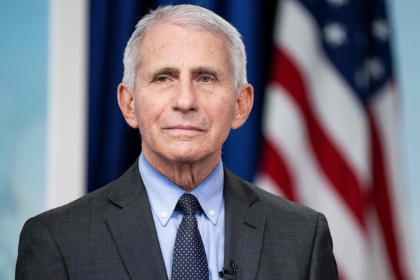 Dr. Anthony Fauci with an American flag visible in the background