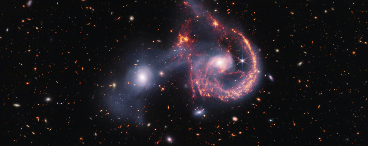 Two galaxies are shown mid-collision against a background of more distant galaxies.