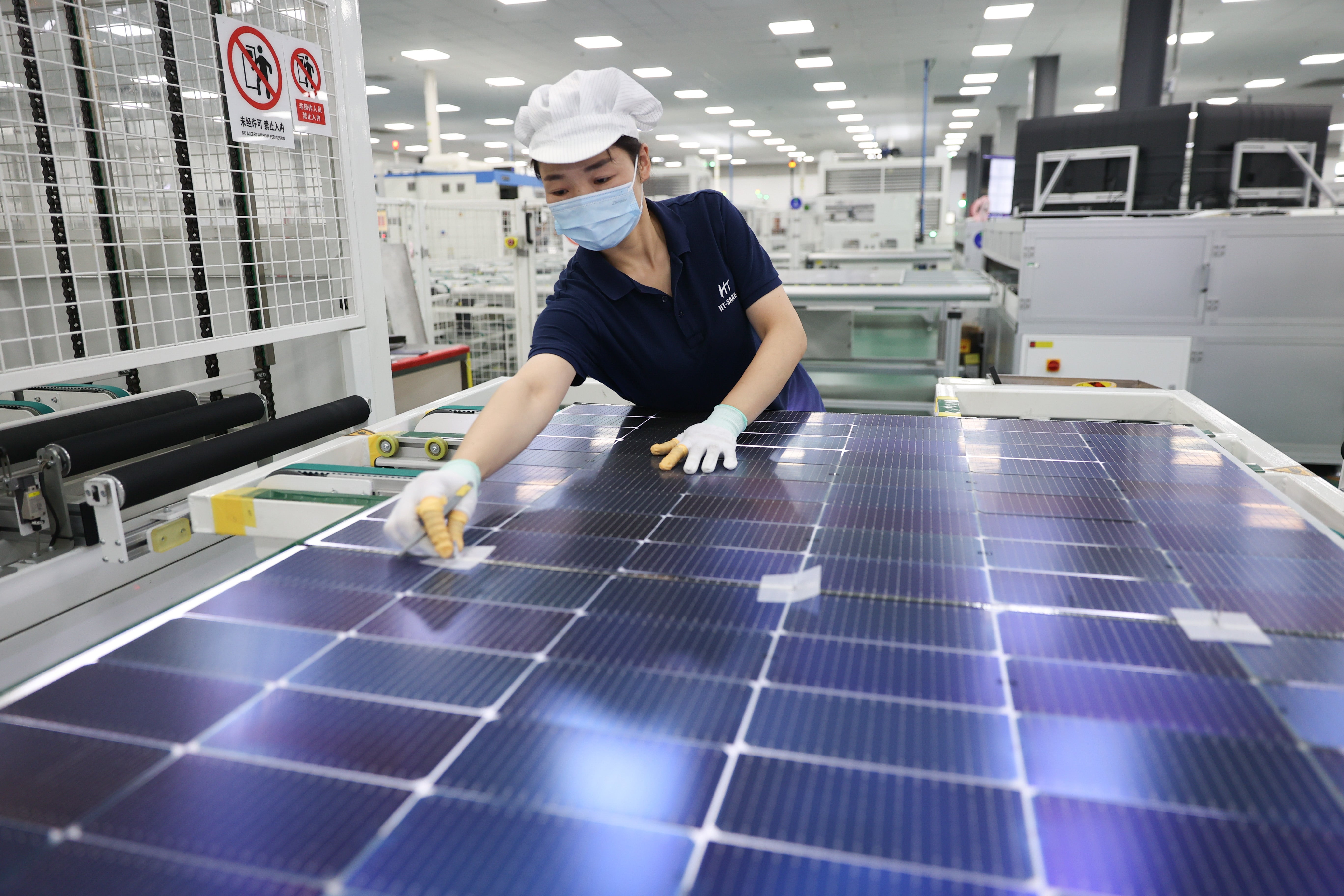Woman with white cap assembling solar panels.