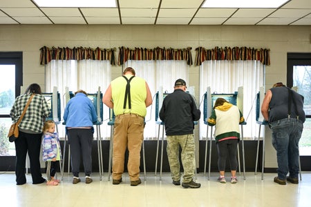 Six people fill out their ballots in voting booths at a polling place in Wisconsin