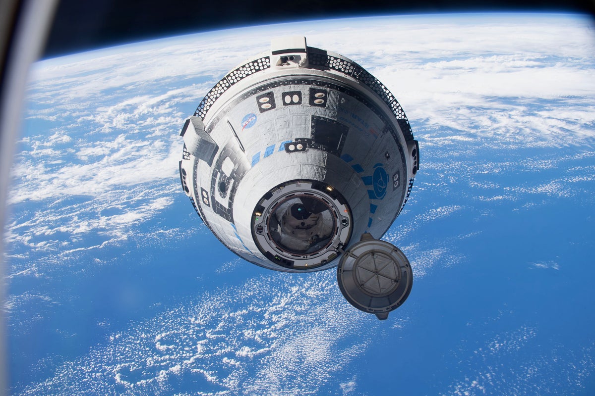 Boeing's Starliner approaching the International Space Station, flying 268 miles above the south Pacific which is seen in the background