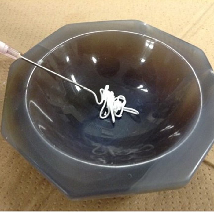 A paste-like artificial bone ceramic material in a black bowl