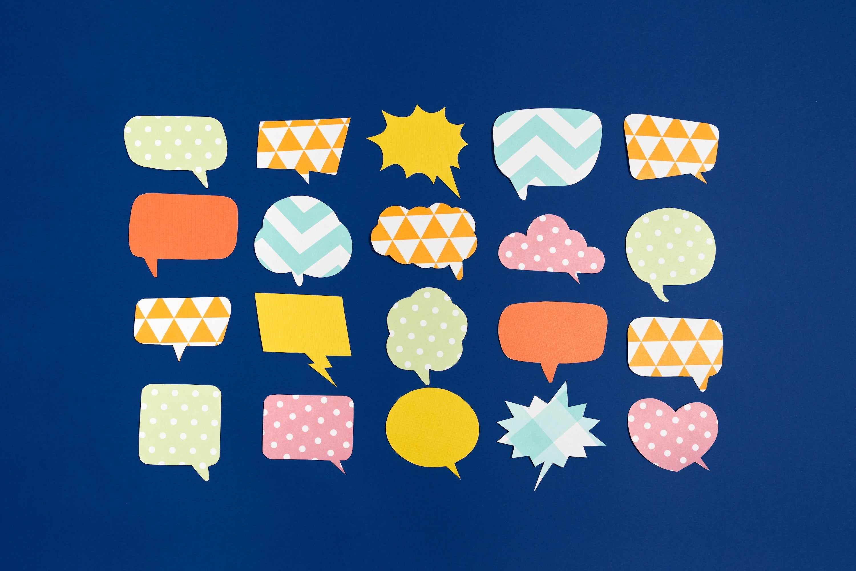 Colorful speech bubbles with different patterns sit as cutouts on a solid background