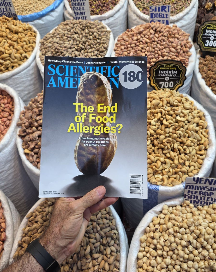 Photo of a magazine held up in front of multiple barrels of nuts