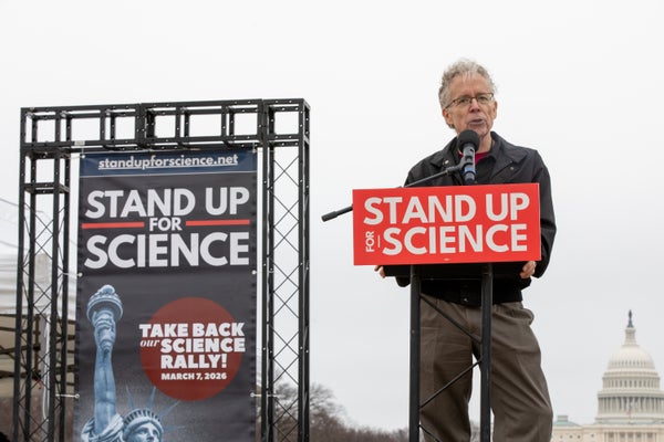 A man standing on a stage with the U.S. Capitol in the background.