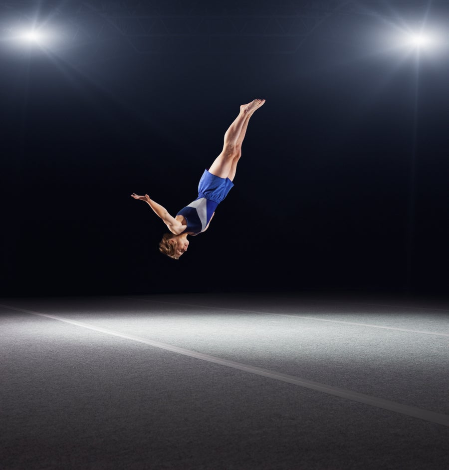 Male gymnast mid-twist
