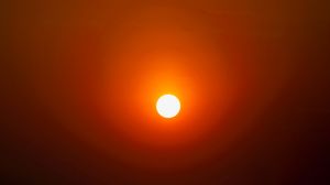Full-frame sun with haze circle shining upward.