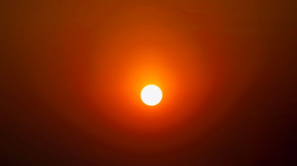 Full-frame sun with haze circle shining upward.