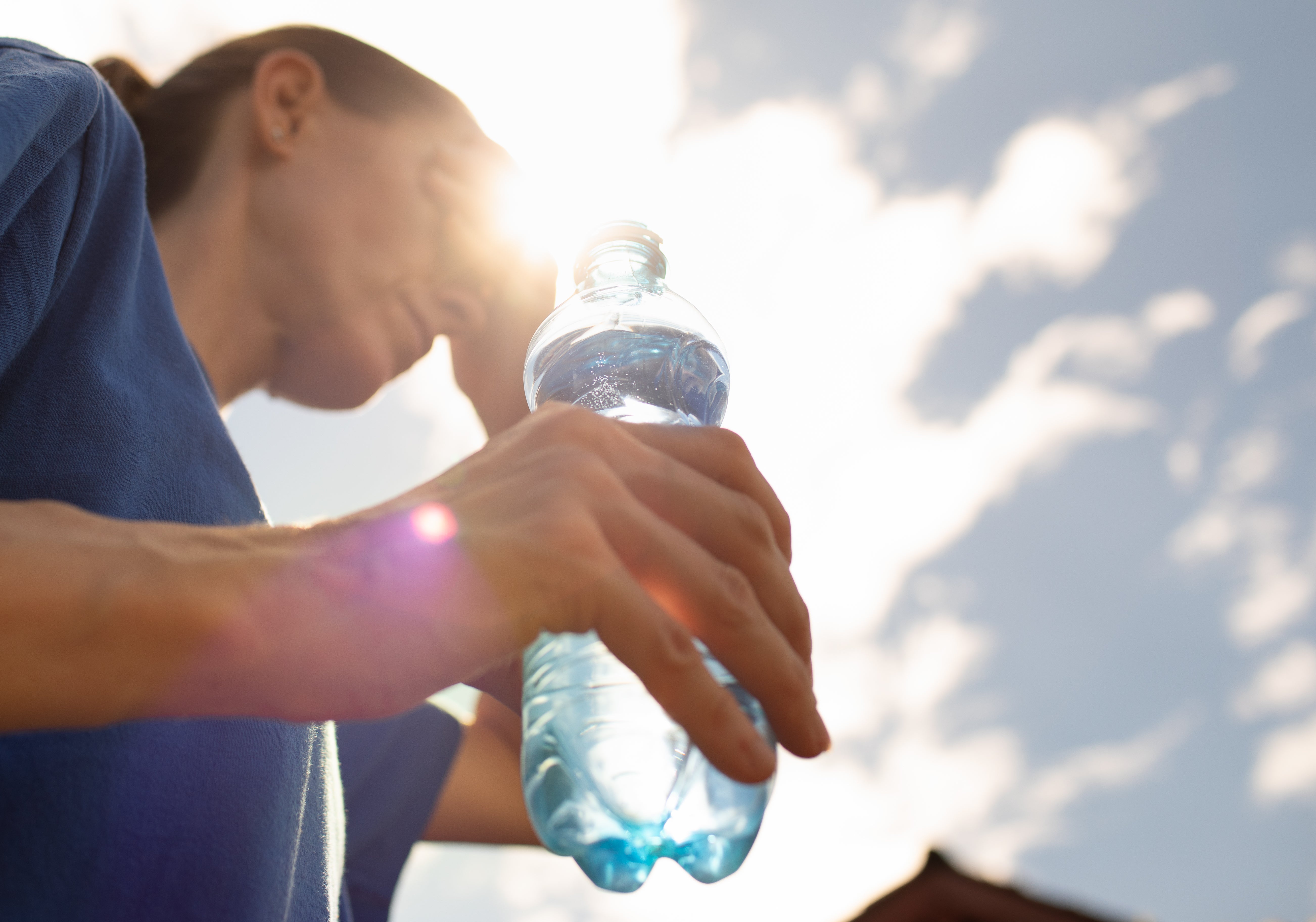 Woman drinks from water bottle replenish fluids