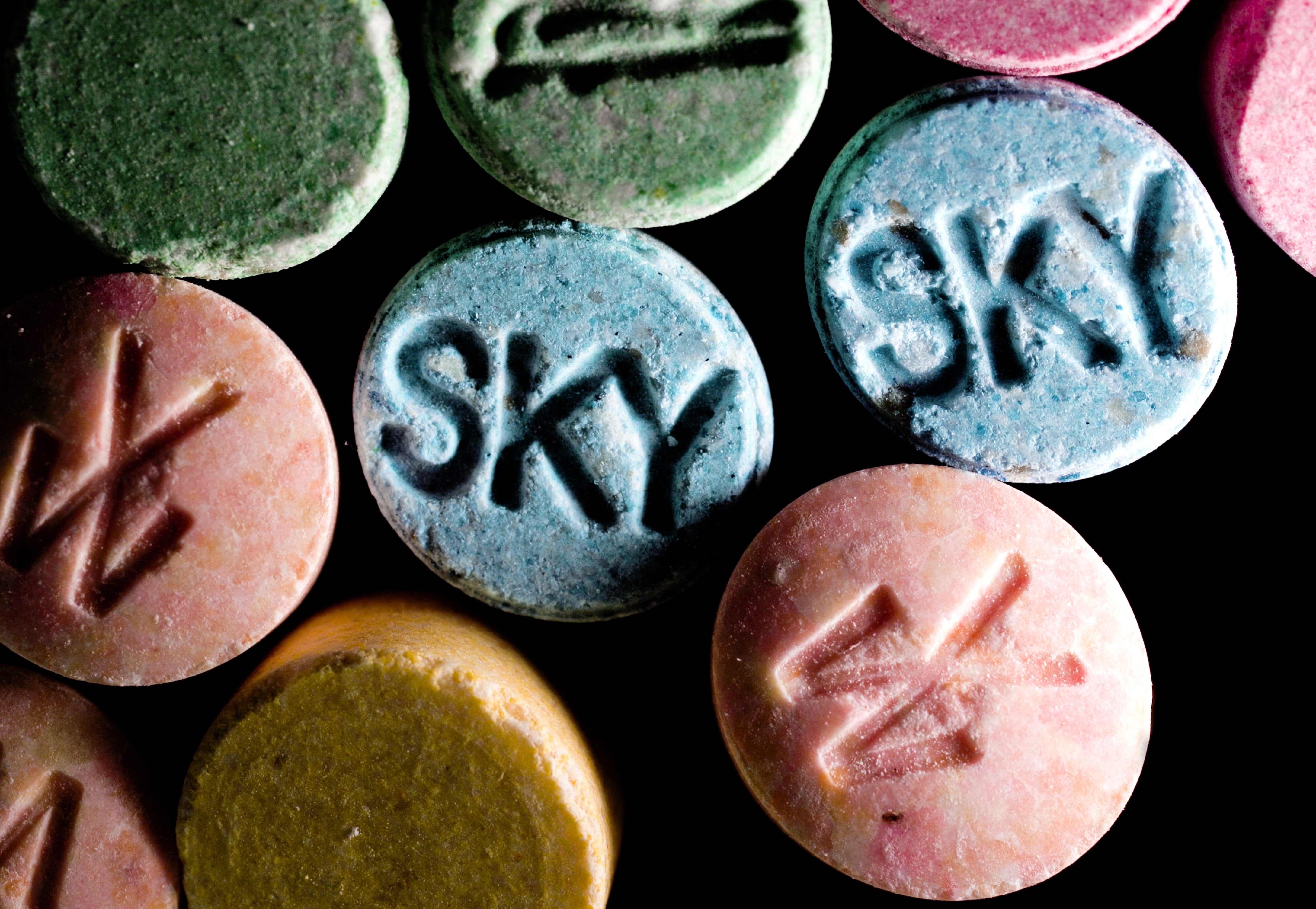 Blue. green, pink and yellow tablets on black background with SKY engravings.