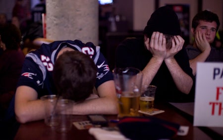 Three fans at a bar, looking dejected