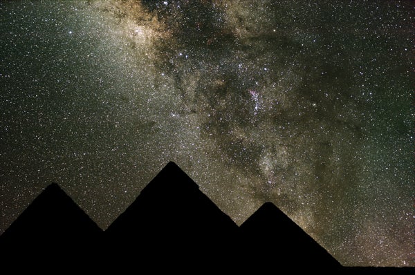 Pyramids silhoutted against the night sky with stars