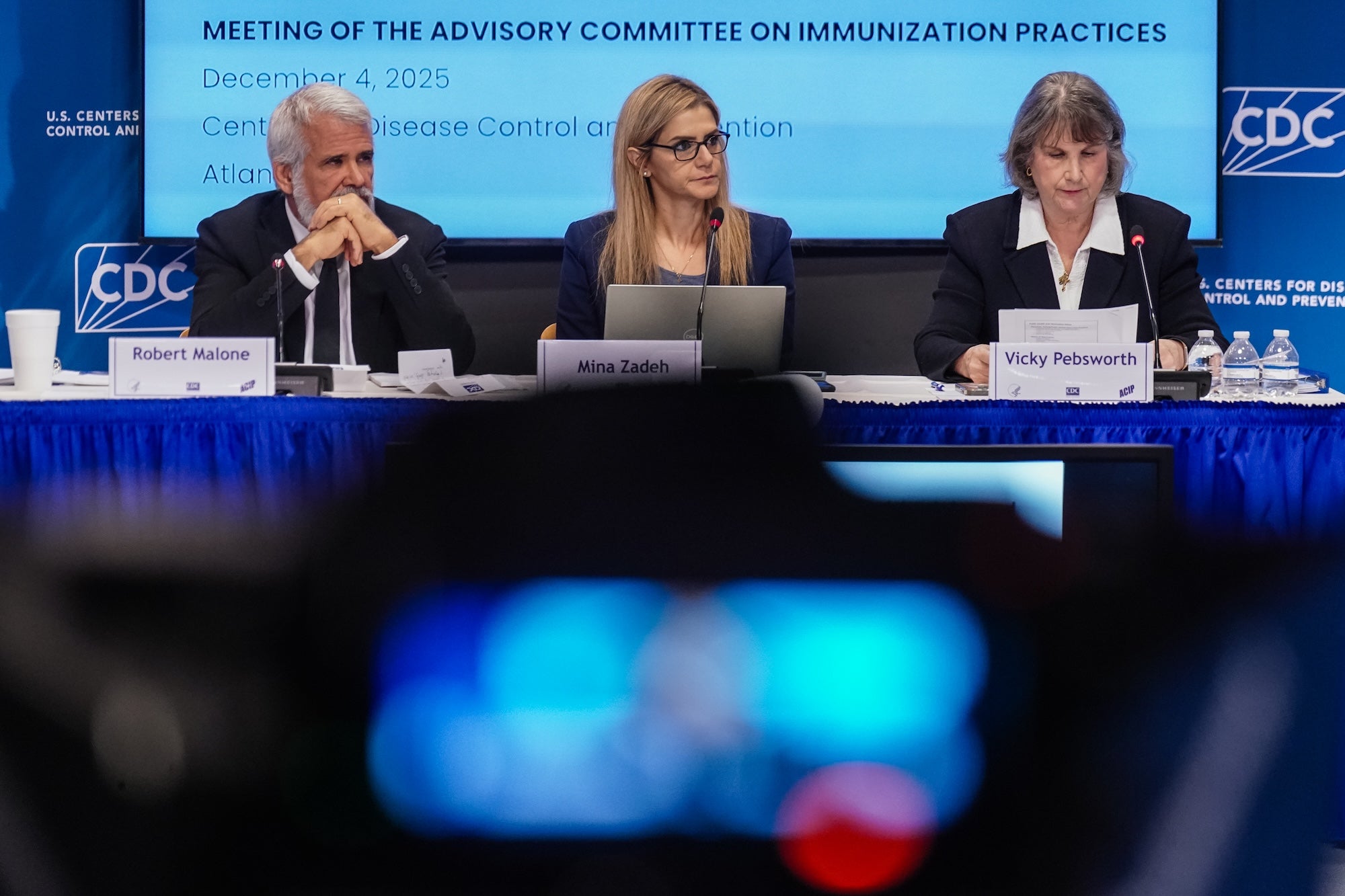 Three people sit at a panel for vaccine policy
