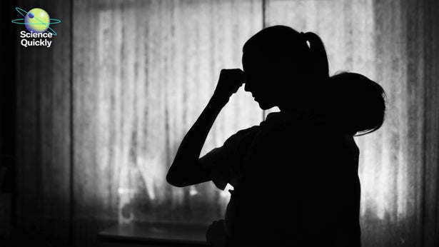 A silhouette of a woman holding her head with one hand and a child in her other arm in black and white
