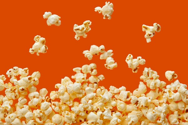 Popcorn jumping up on orange background