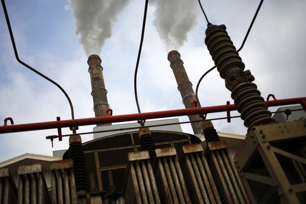 An electrical transformer stands behind a power plant in Kentucky