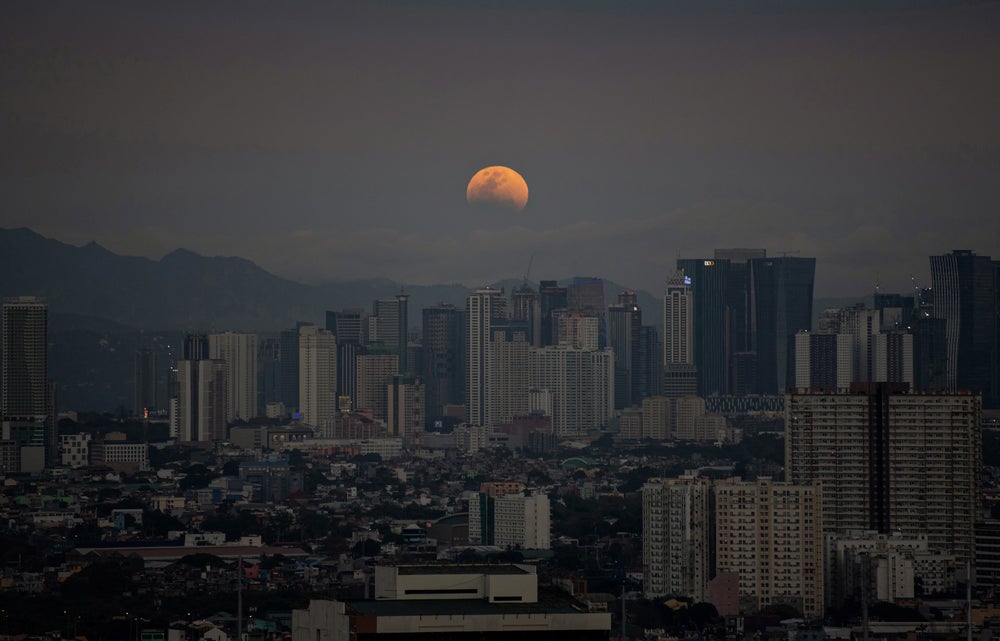 una luna tenue detrás de los edificios