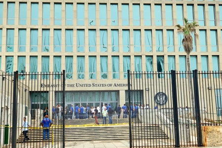 美州入口前人员视图驻古巴哈瓦那大使馆通过开放黑条安全门、链锁栅栏和警告磁带