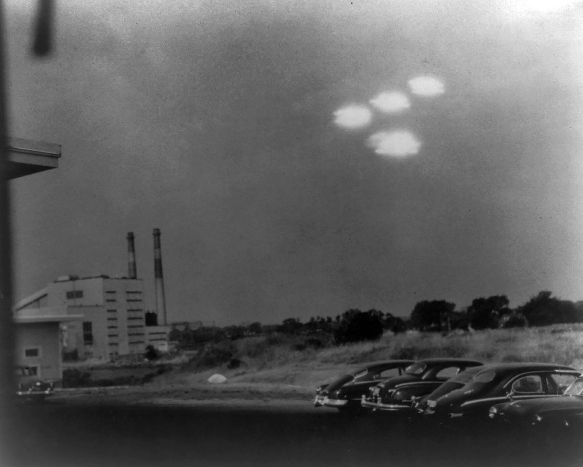 Black-and-white photo of four unidentified flying objects (UFOs) above a U.S. power plant