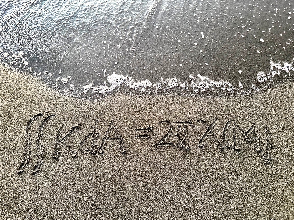 Math equation written in sand.