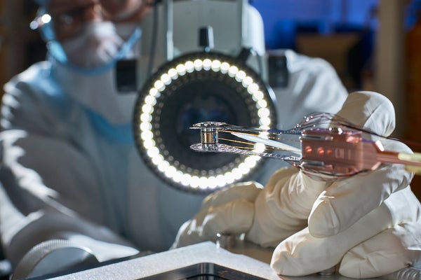 Close up of a Target Pre-Fabrication Facility Technician bonding Thermal Mechanical Packages (TMP), fill lines, and diagnostic band windows using adhesive placed on a human hair