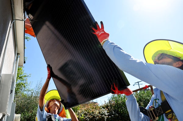 2 workers installing solar panels.