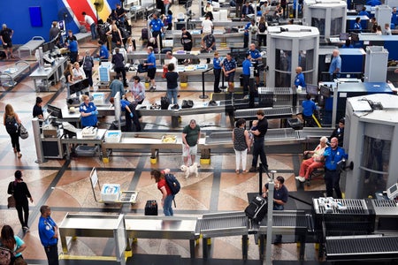 Airplane passengers proceed through a TSA security checkpoint