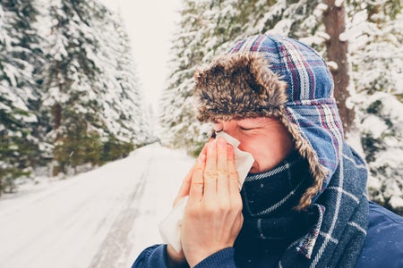 Man in winter scene with hat and tissue