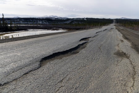 Close-up of highway with holes from damaged by thawing permafrost