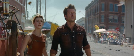 Daisy Edgar-Jones and Glen Powell stand on a street in a film still from Twisters