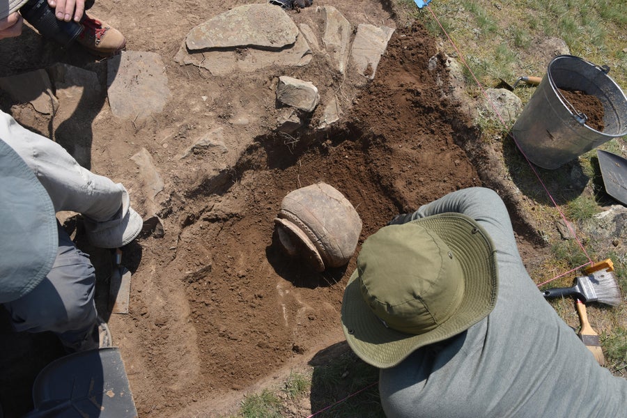 Archeologists excavate a large medieval pot