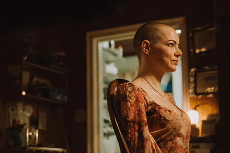 A photo of Emma Stone shaved bald in a scene from Bugonia