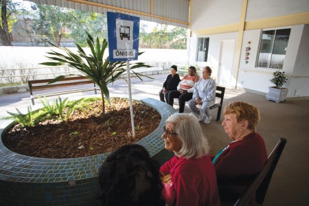 A group of people sitting outside on benches