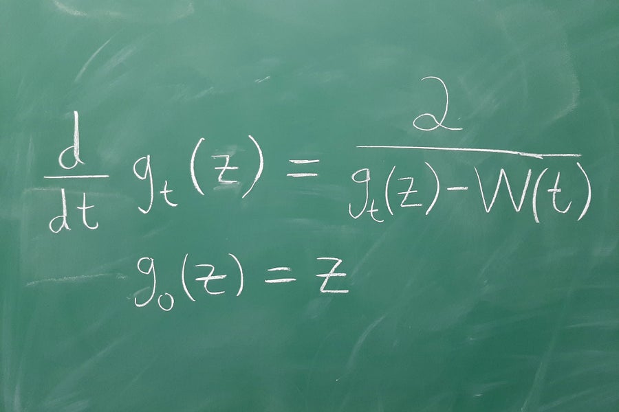 Math equation written in white on green board.