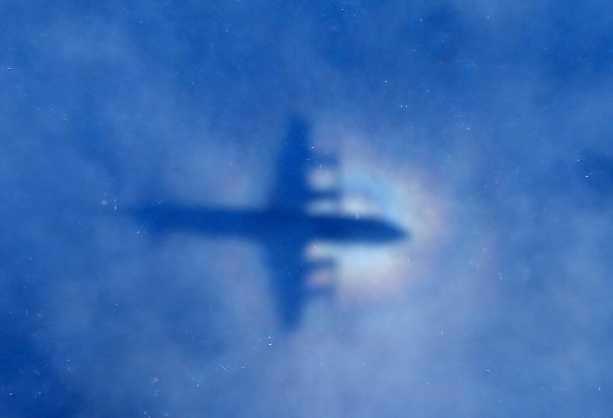 This shadow of a Royal New Zealand Air Force P3 Orion aircraft is seen on low cloud cover while it searches for the missing Malaysia Airlines Flight MH370 over the Indian Ocean on March 31, 2014.