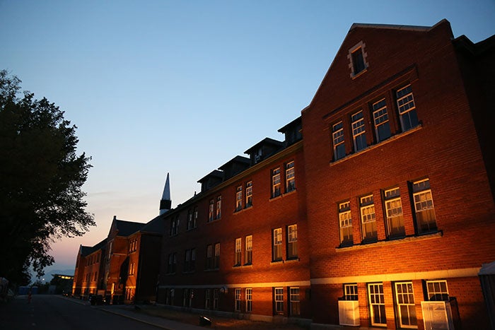 An illuminated brick building shown in evening light.