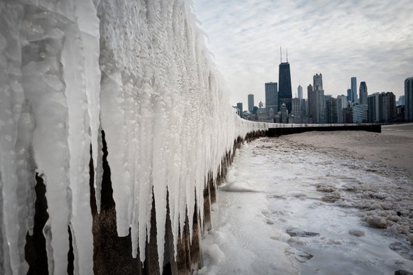 The ice gathered on the edge of Lake Michigan, with large ice creams hanging on a wall and the chicago horizon
