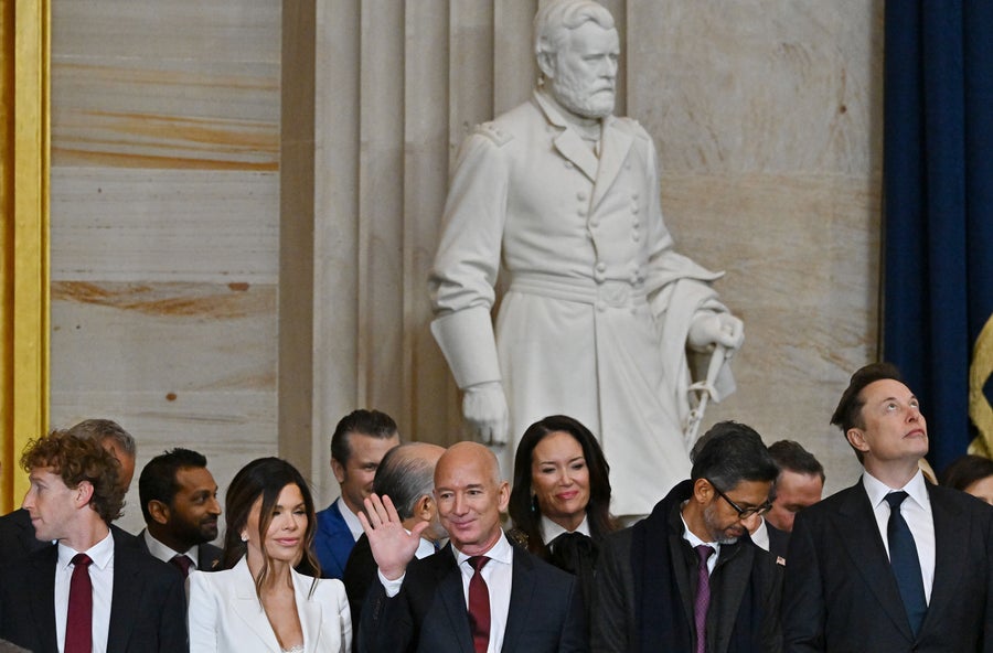 Meta CEO Mark Zuckerberg, Lauren Sanchez, Jeff Bezos (seen waving to someone off-camera), Google CEO Sundar Pichai and Tesla CEO Elon Musk stand next to each other while attending the 60th inaugural ceremony where Donald Trump will be sworn in as the 47th president on January 20, 2025, in the US Capitol Rotunda in Washington, DC