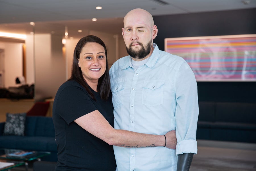 Aaron James and his wife Meagan embrace and pose for a portrait inside NYU Langone