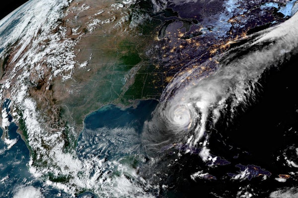 Satellite image of Hurricane Ian over Florida. The eastern U.S. is in darkness and city lights are visible, whereas it is still daytime in the western half of the country.